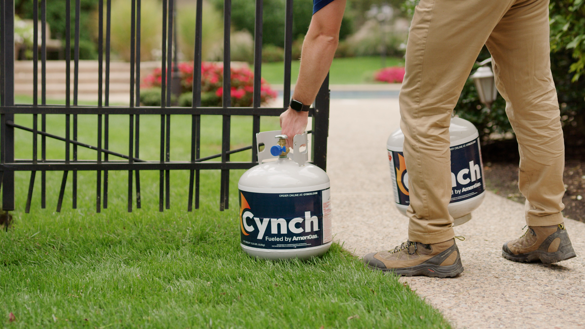 Person picking up Cynch branded portable propane tank