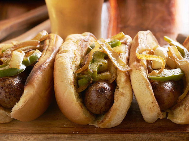 Bratwurst on rolls with peppers and onions