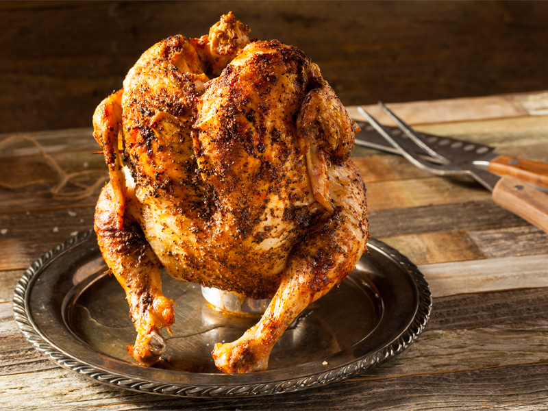 Whole roasted chicken standing up on a beer can 