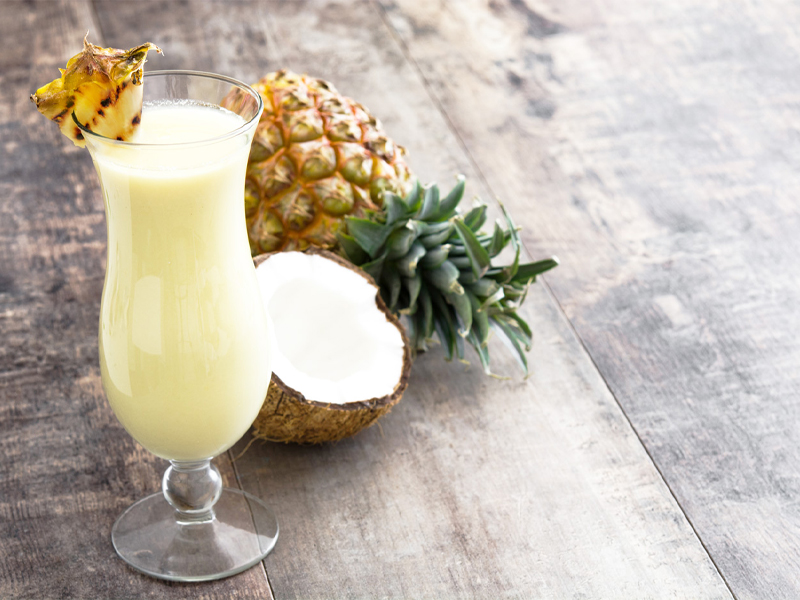 pina colada in glass next to a pineapple