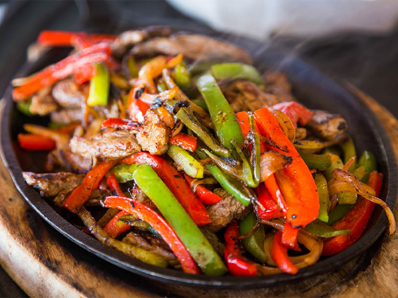 fajita peppers and onion with chicken in a skillet