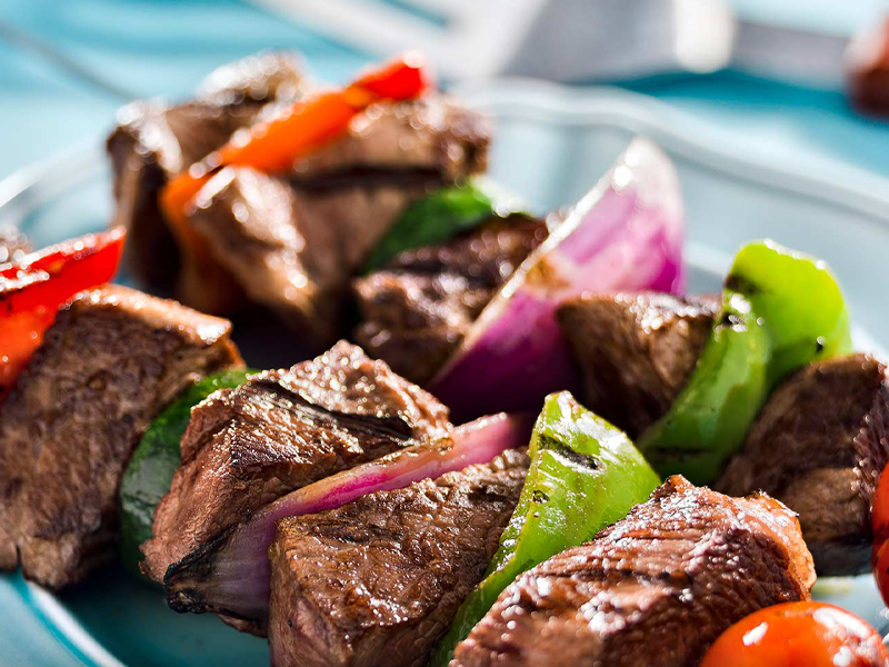 Steak peppers and onions on grilling skewers