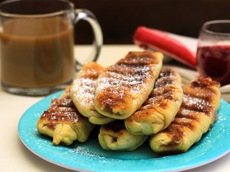 croissants with cheesecake filling staked up on a  plate