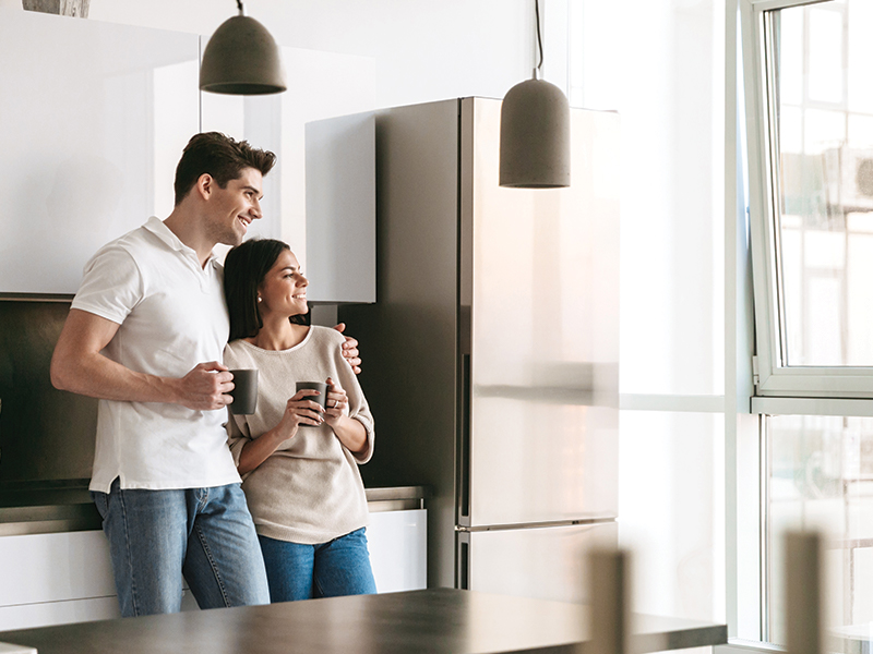 Man and Woman casually look out the window of kitchen