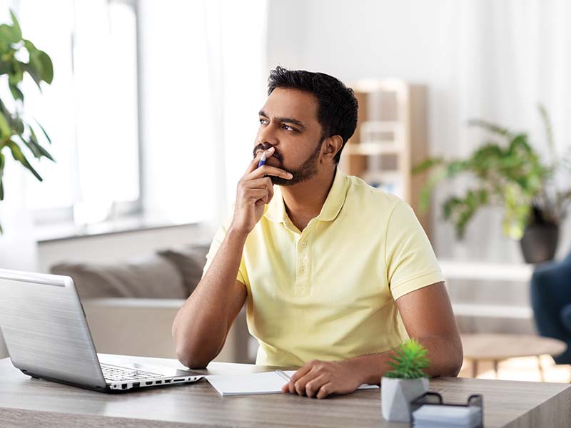 Man on his computer debating which propane tank size to choose