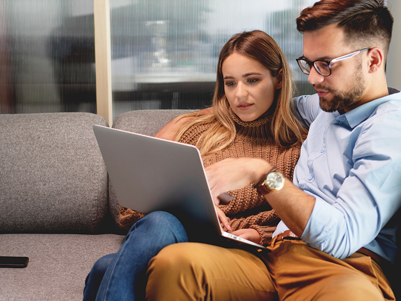 Man and woman point and browse on the laptop for propane rental