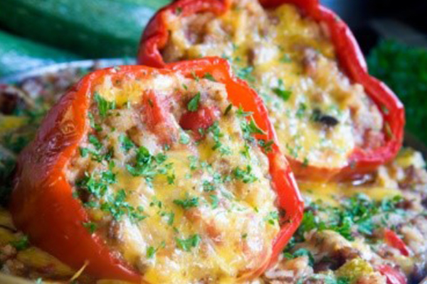 Two cheesy stuffed peppers on a plate