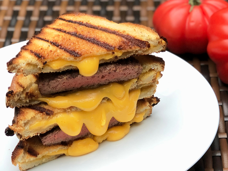 Grilled cheeseburger patty melt on bread