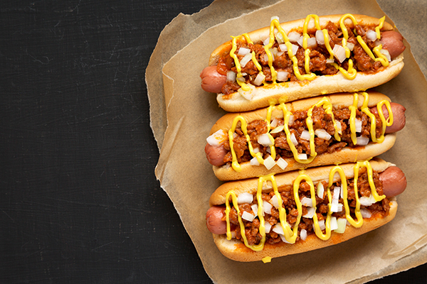 Three chili cheese dogs with onions and mustard 