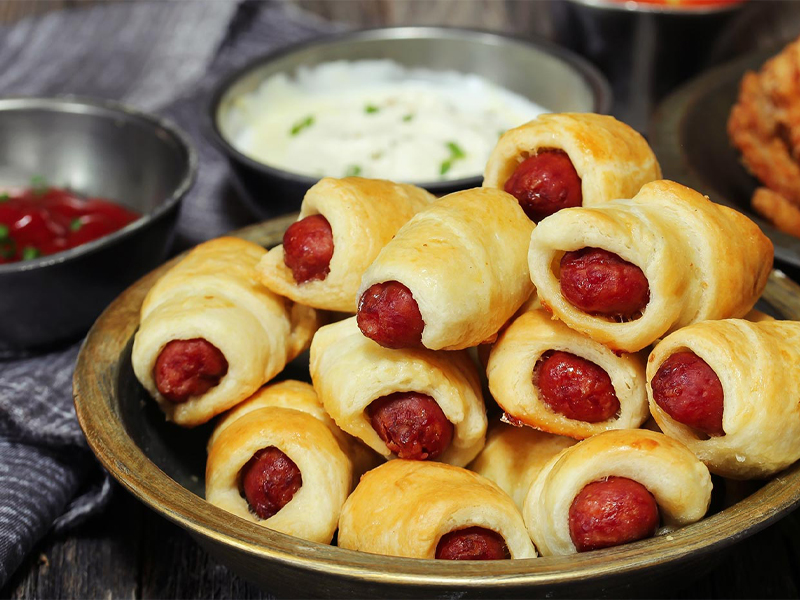 pigs in blankets or mini hot dogs wrapped in dough on a plate