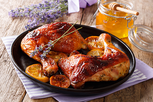 Honey Chicken with lavender on a black plate