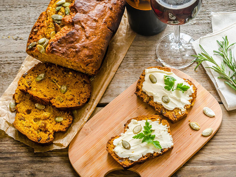 Sliced pumpkin beer bread on wood cutting board