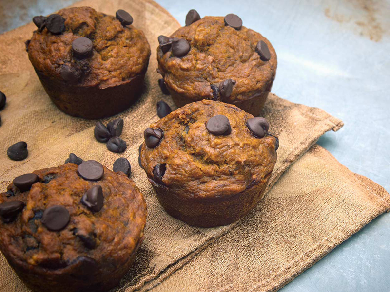 Pumpkin chocolate chip muffins on paper bags