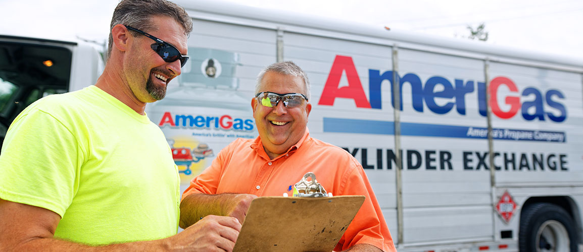 Two men with clipboard in front of an AmeriGas truck.