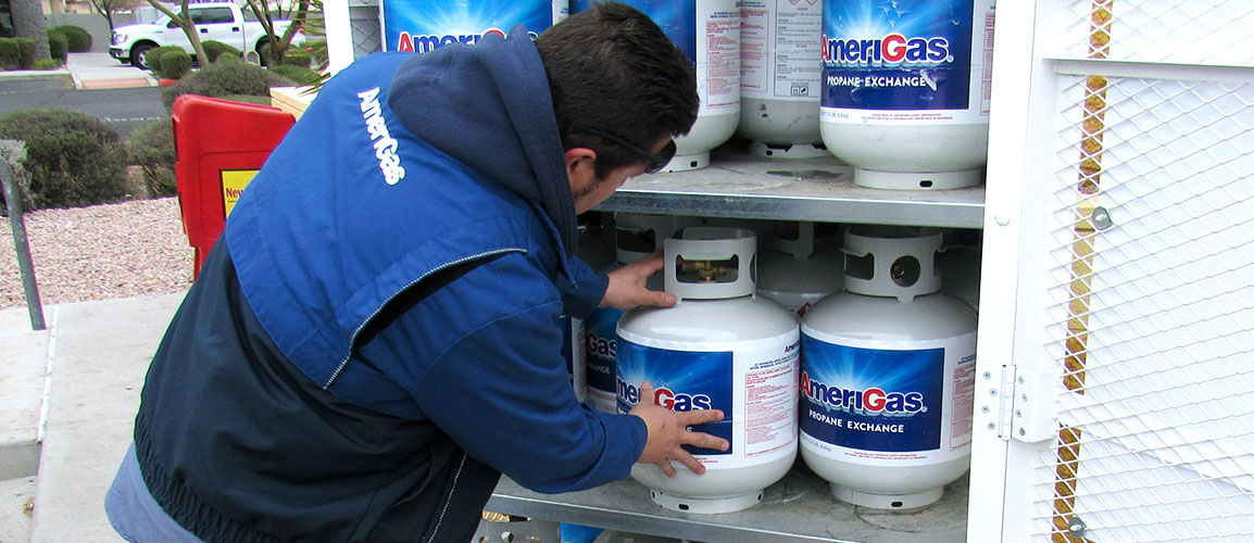 Man loading propane tanks into truck.