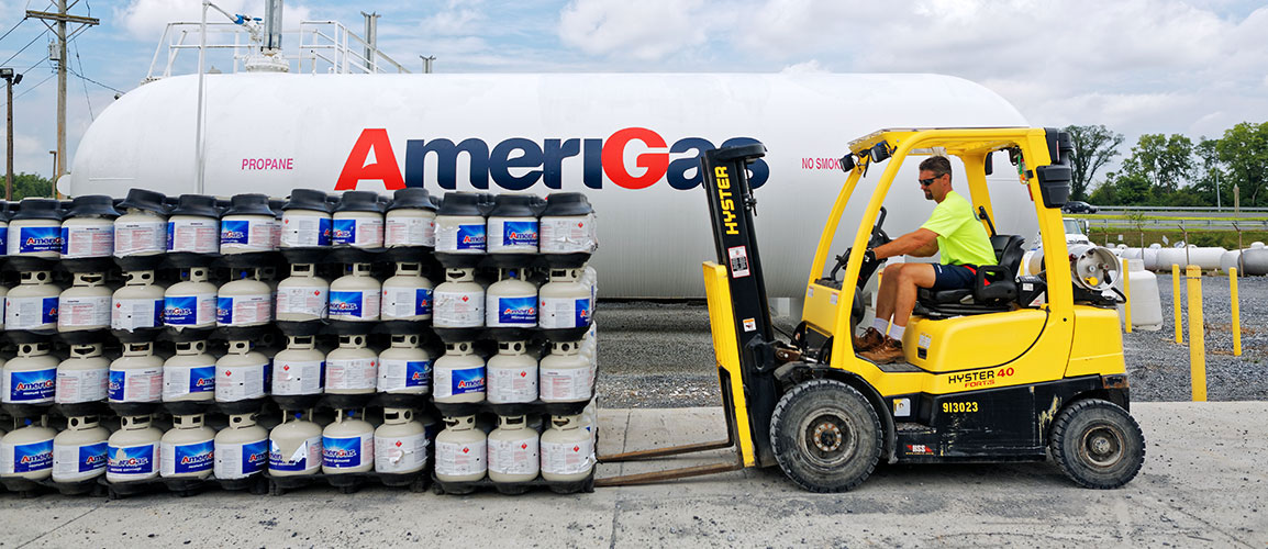 Man driving forklift in a propane workyard.