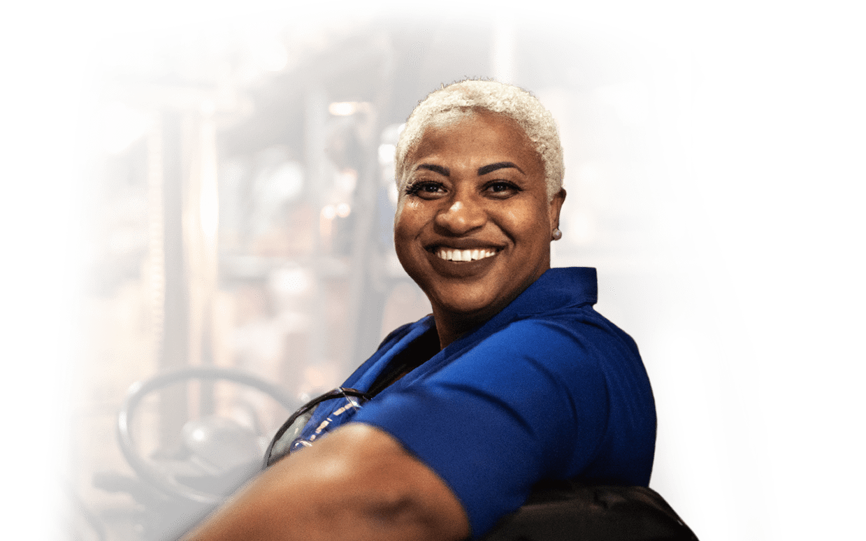 Woman smiling while seated on a forklift