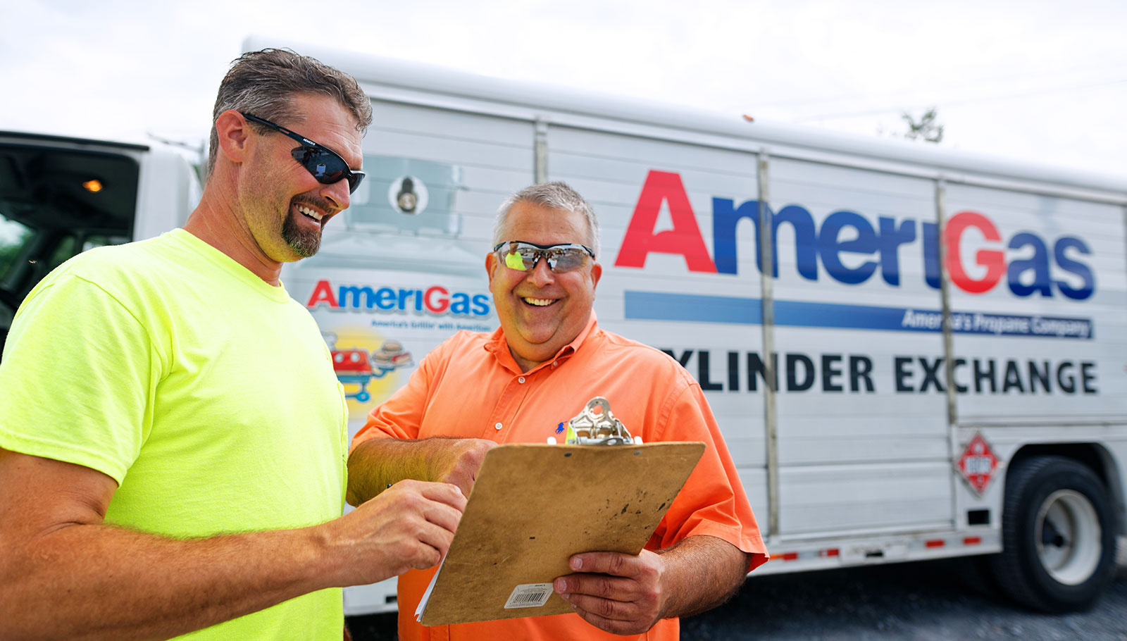 Two men with clipboard in front of an AmeriGas truck.