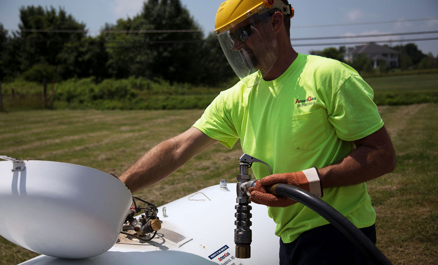 Man filling large propane tank.