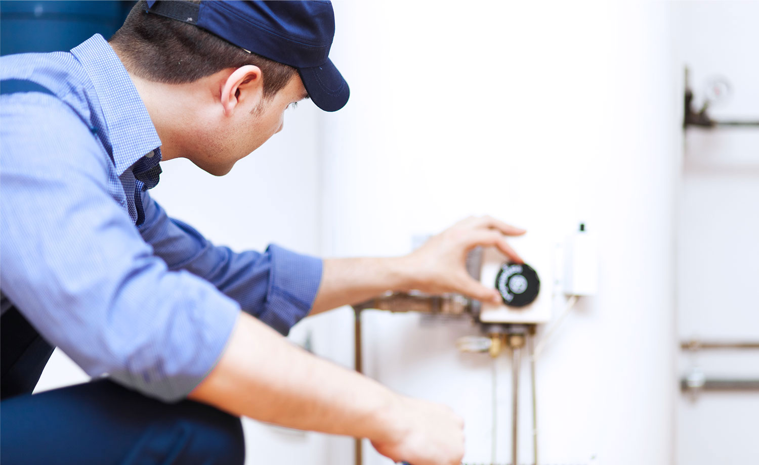 Inspector looking at water heater thermostat.