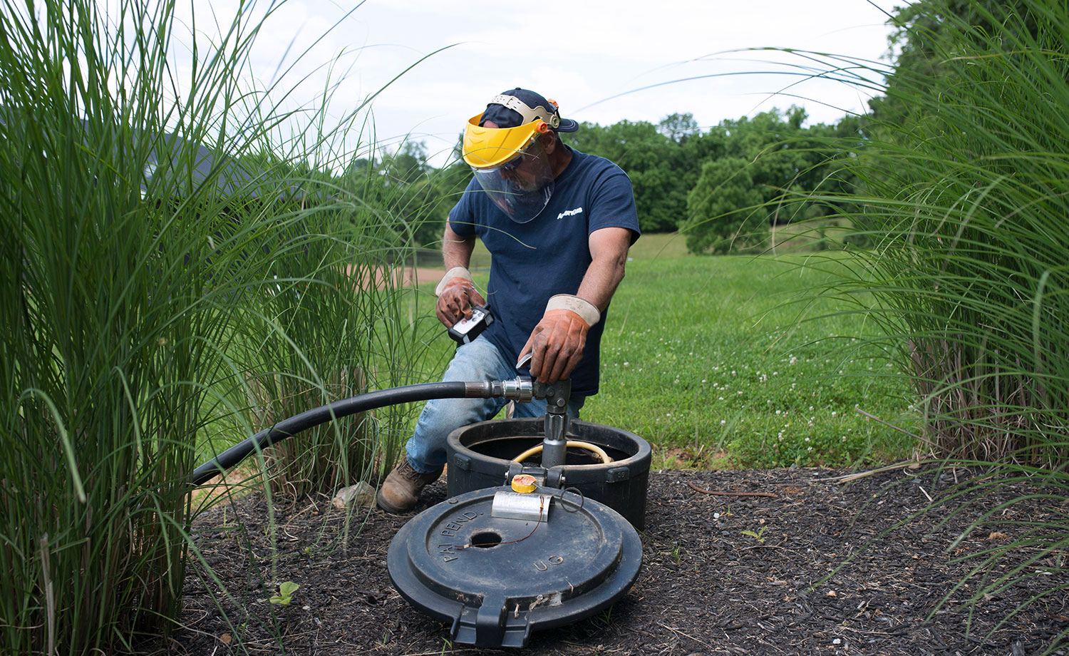 Person refilling underground propane tank.