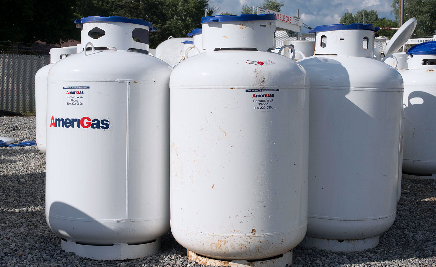 Several 120 gallon propane tanks standing upright