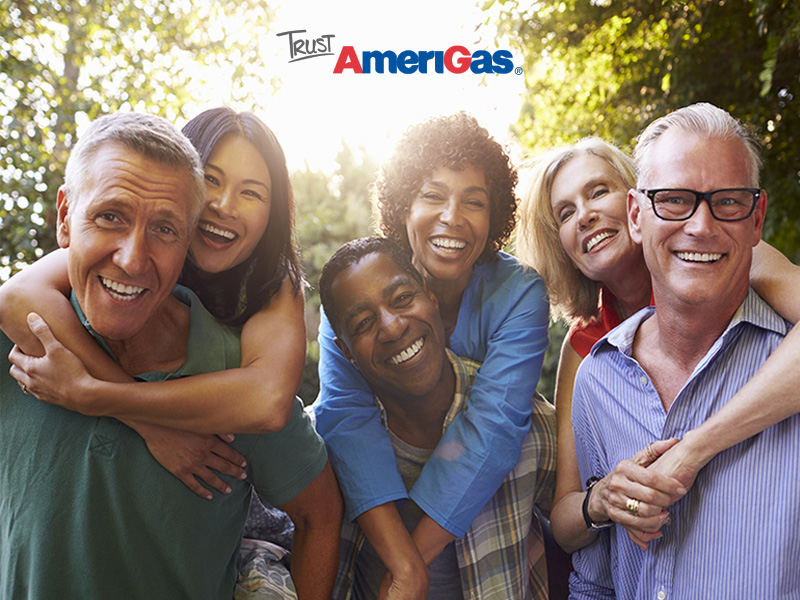 Three couples smiling in front of trees and sunshine with the Trust AmeriGas logo