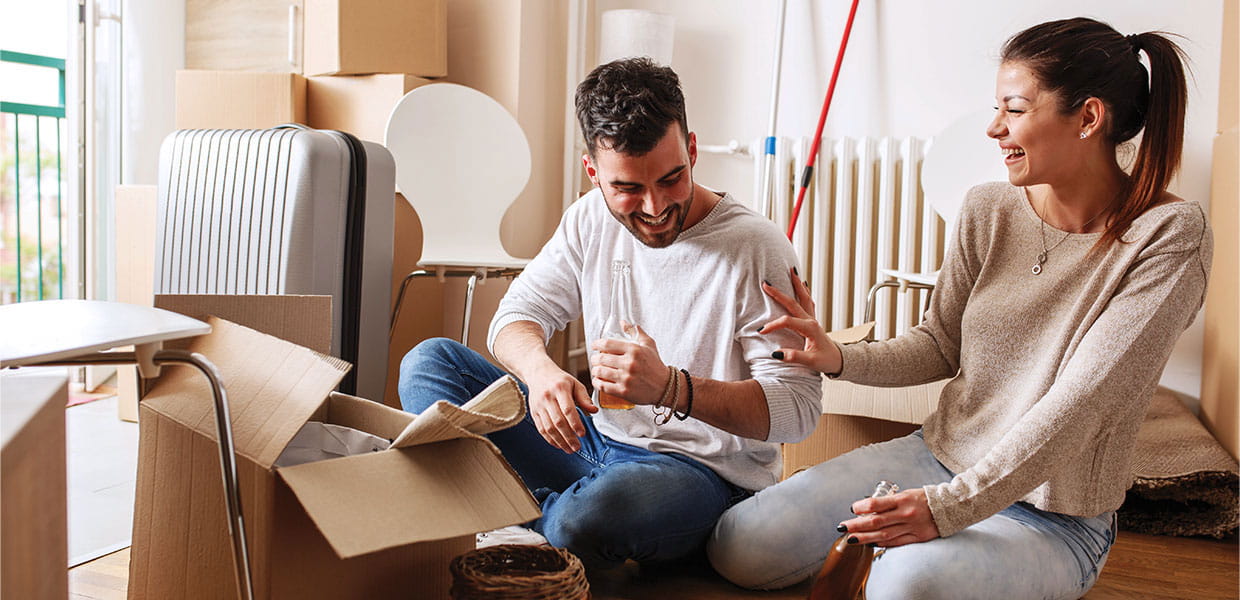 People sitting in room surrounded by moving boxes.