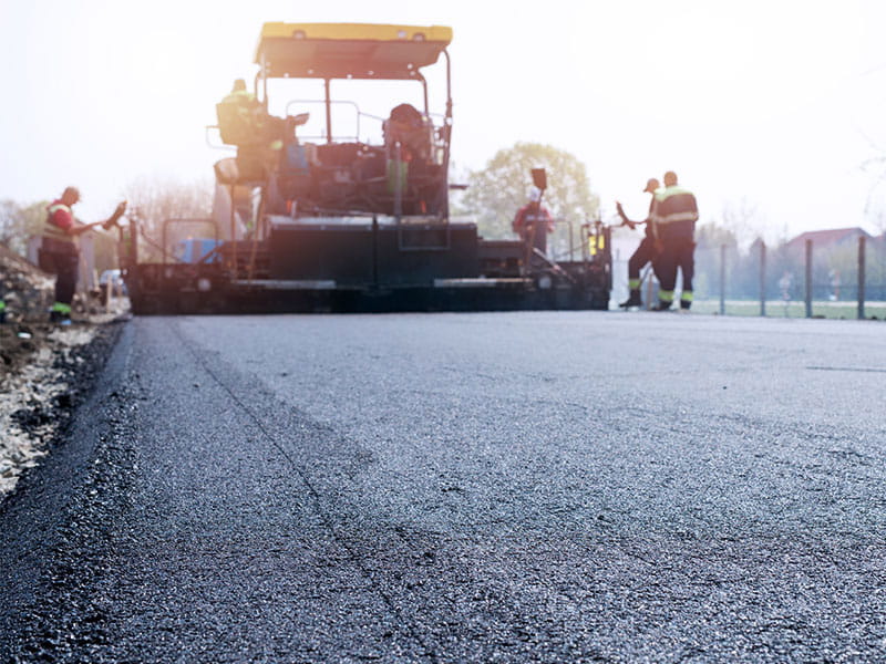Road crew laying asphalt.