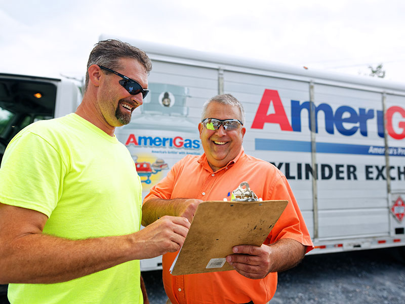 Two men with clipboard in front of an AmeriGas truck.