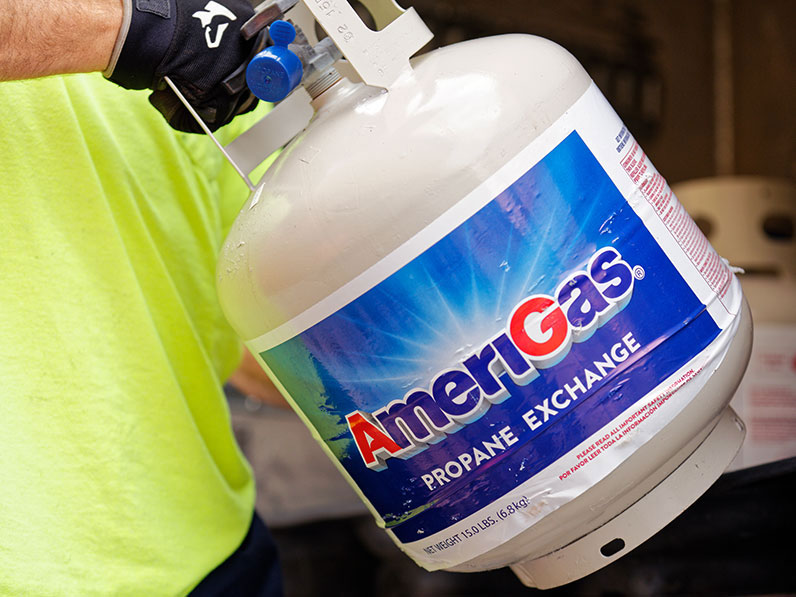 Person holding an AmeriGas propane tank.