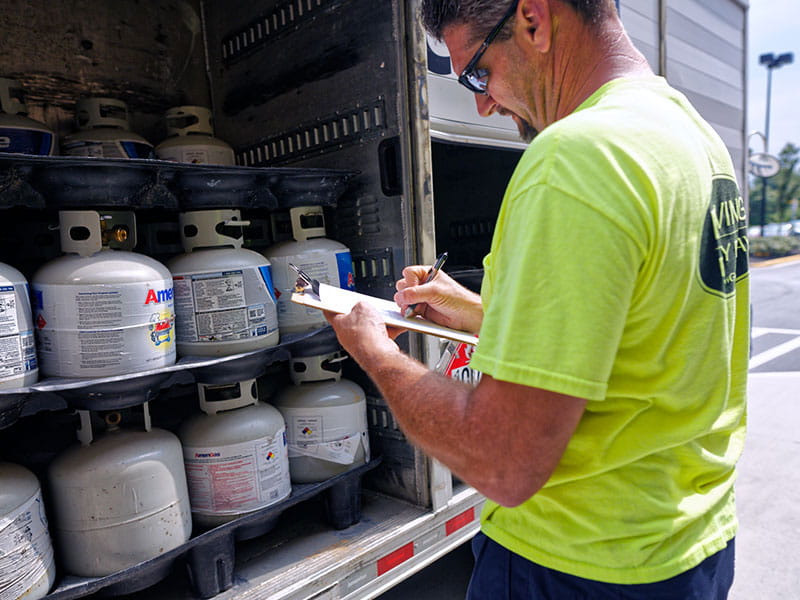 Person checking propane tank stock.